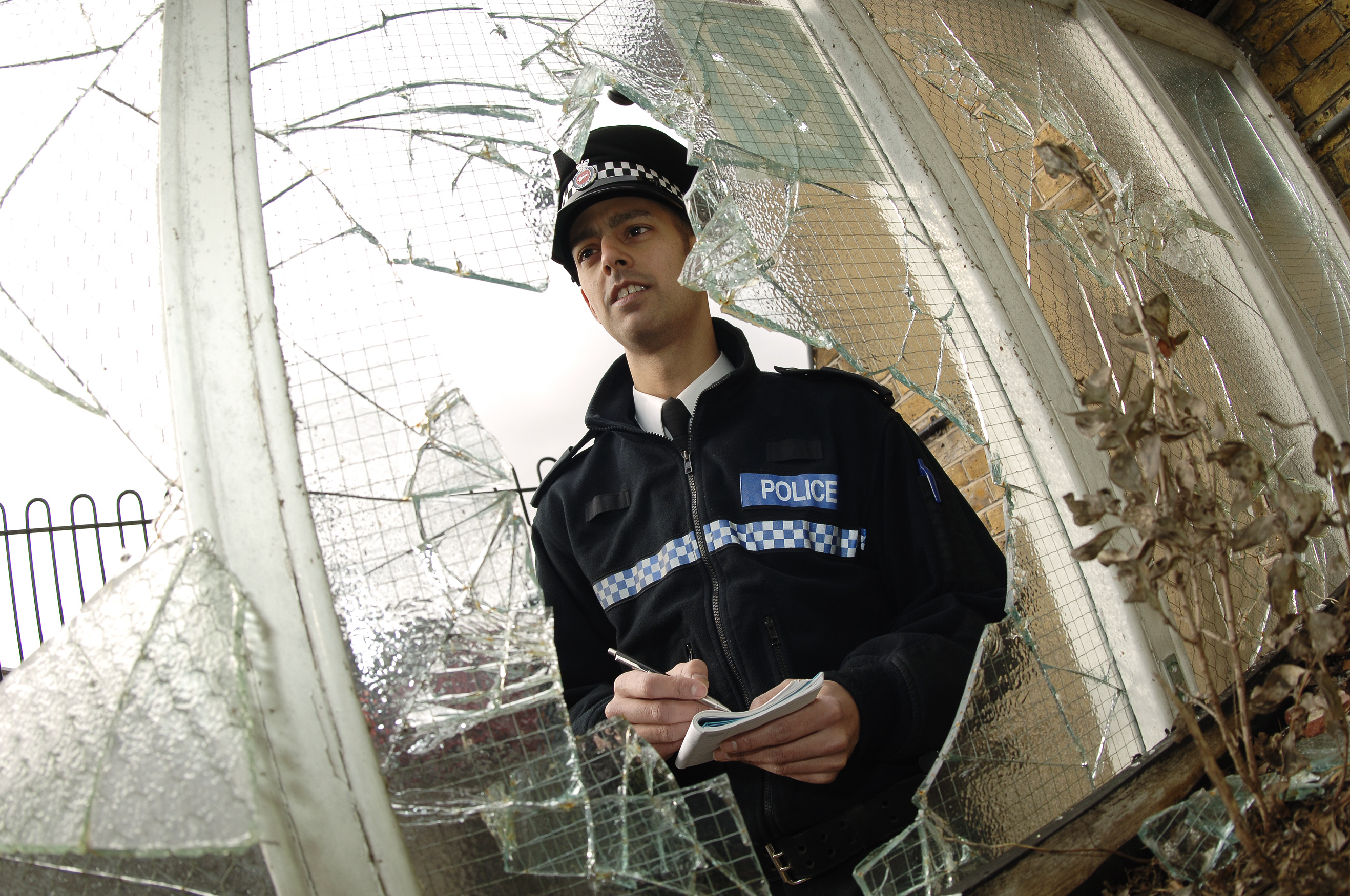 Officer looking at a broken window