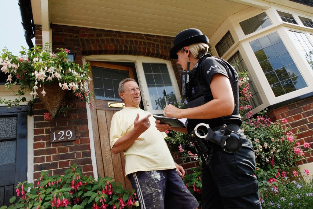 Police Officer with a resident conducting door to door enquiries