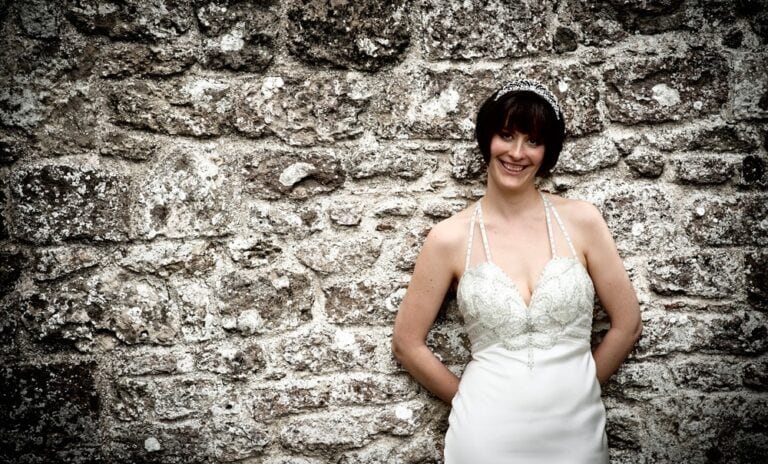 Bride leaning against a stone wall