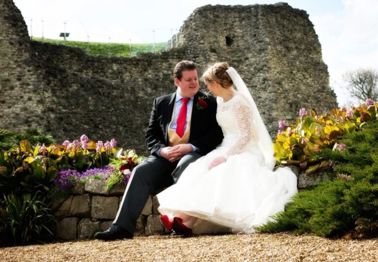 Bride sat on wall with red shoes