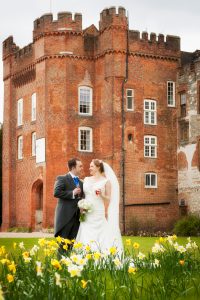 Bride and groom and daffodils at Farnham Castle