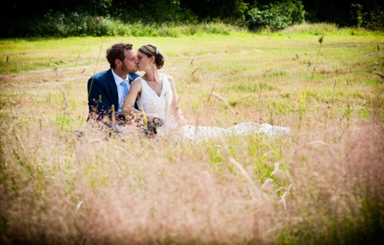 Bride and groom sitting in a summer meadow