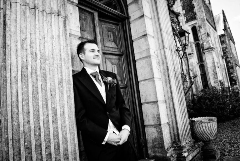 Black and white image of a groom in a doorway