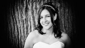 Bride leaning on a tree