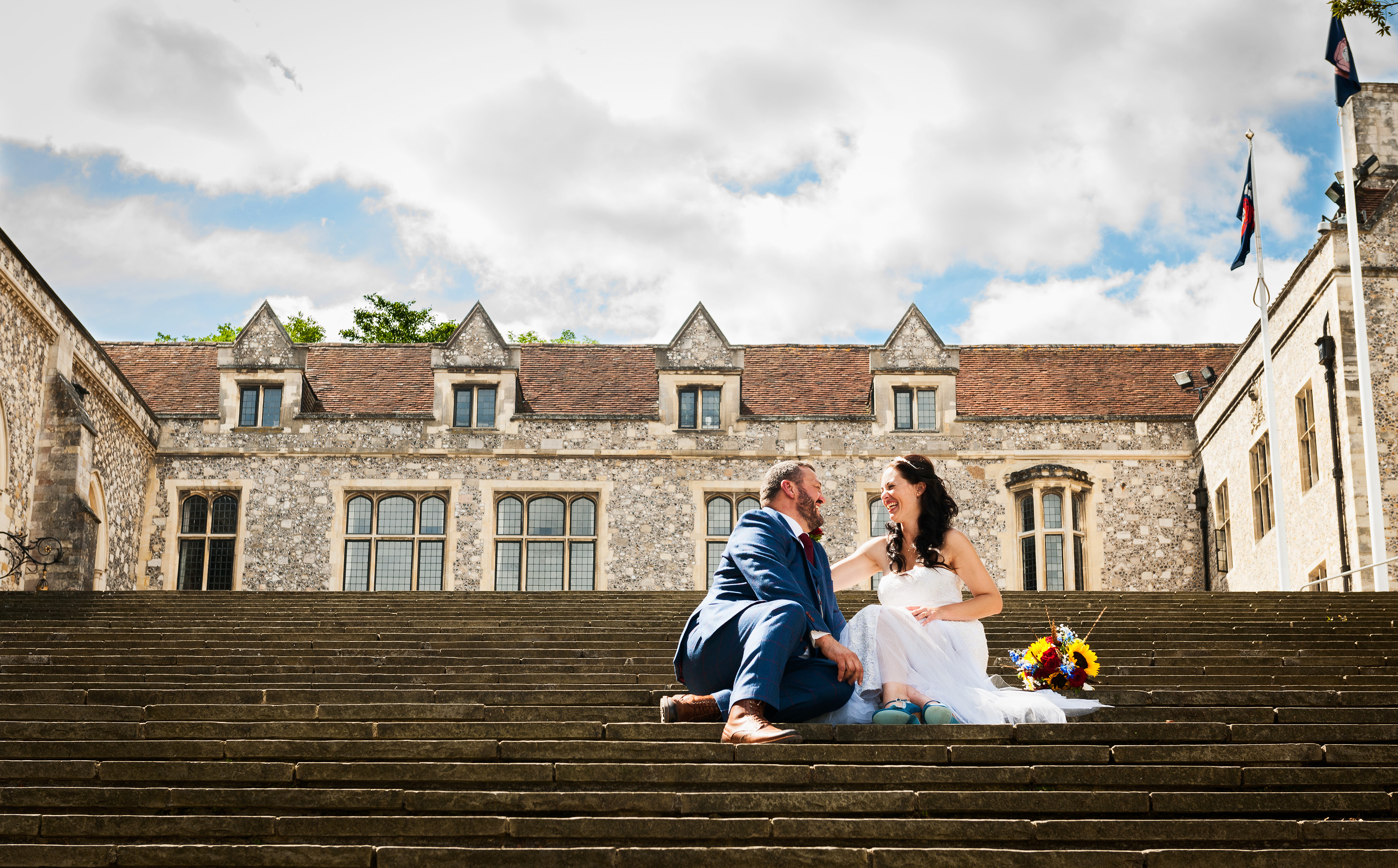 Wedding coupleon the steps at The Great Hall, Winchester