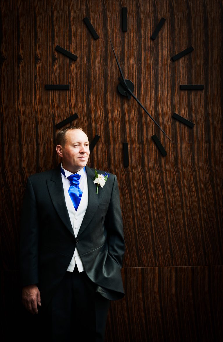 Groom by big clock at Harbour Hotel, Guildford