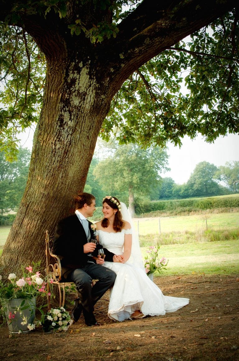 Bride and Groom sitting under an oak tree