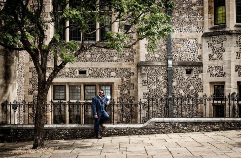 Cool groom against a stone building