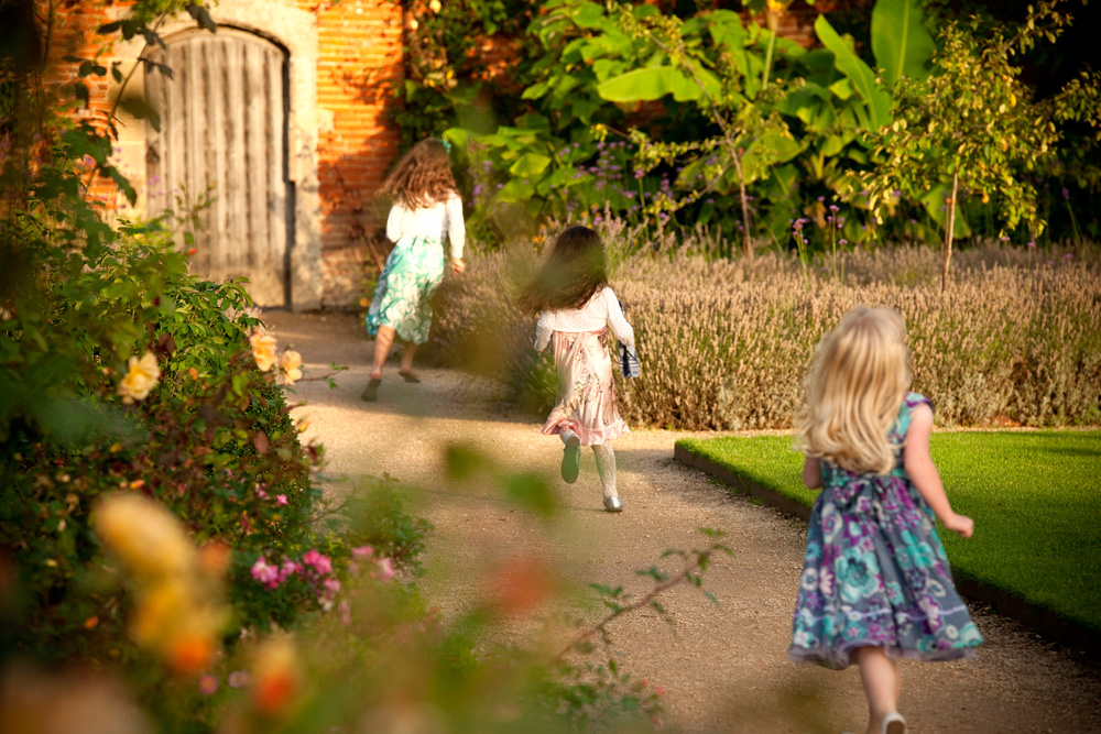 Girls running through The Walled Garden at Cowdray, wedding