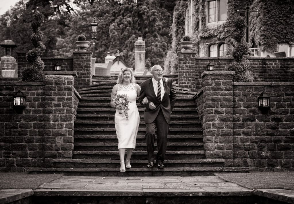 Father walking his daughter to her outdoor wedding