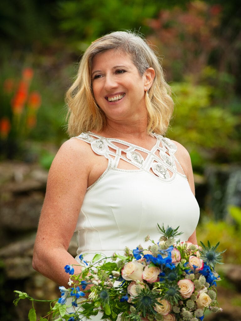 Bride outside in a garden holding her bouquet