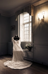 Vintage wedding dress on a chair by the window