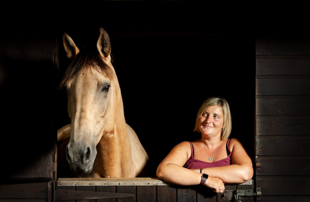 Horse and owner leaning over a stable door