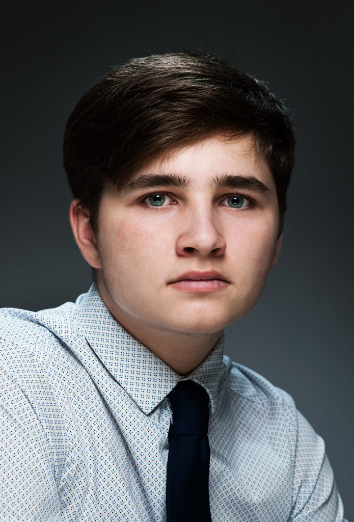 Young man looking serious in a head and shoulder portrait